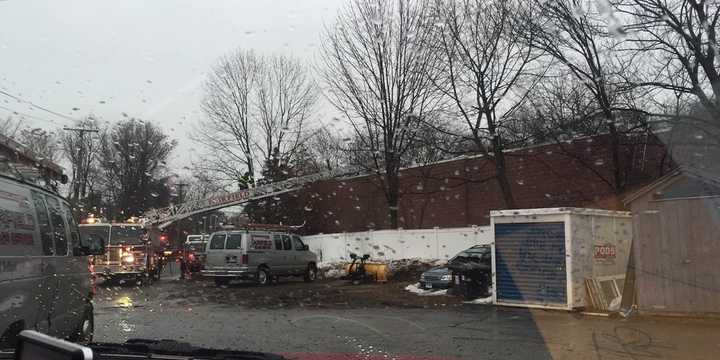 An aerial ladder is deployed on the Rennell Drive side of building to provide access and power tools for roof operations over obstructions. Photo was taken after the fire was extinguished. 