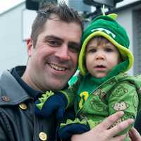 <p>A Yonkers police officer enjoys the parade with his young child.</p>