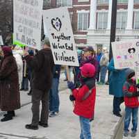 <p>Children hold signs in front of Town Hall as they await Team 26&#x27;s arrival.</p>