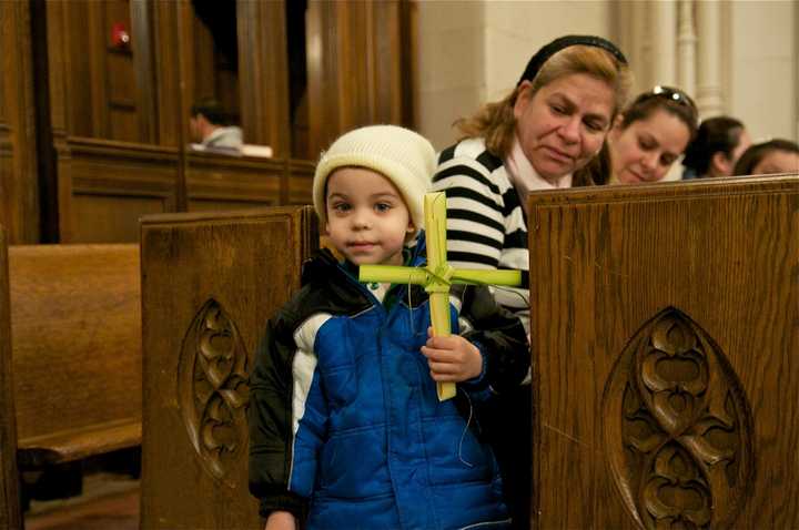 A young boys holds his palm cross at St. Mary&#x27;s on Palm Sunday.