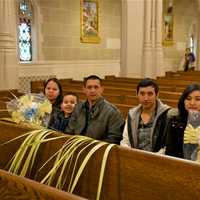 <p>A family sits in St. Mary&#x27;s with palms after Palm Sunday service.</p>