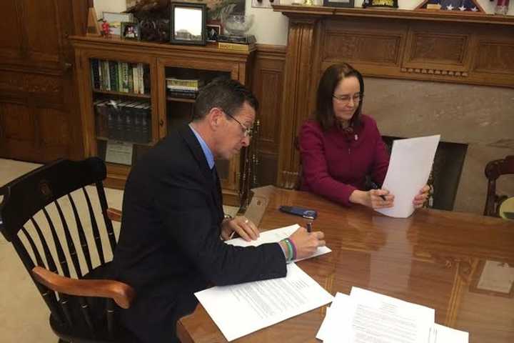 Connecticut Gov. Dannel Malloy signs the executive order Monday in his office. 