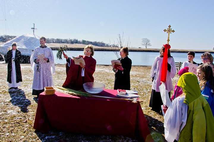 The Rev. Peggy Hodgkins performs the blessing of the palms on Sunday, March 29, on Perry Green at the Southport Harbor.