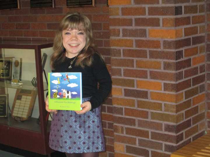 Alena Galan holding up her new book &quot;Differences Are Blessings.&quot;