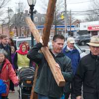 <p>Walkers carry the cross from the First Congregational Church to St. Luke Episcopal on Good Friday.</p>