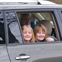 <p>Phoebe Bryan (L), 8, and cousin Katherine Drugge, 7, of Darien, watch walkers carry cross, as Heather Drugge looks on.</p>