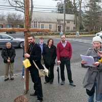 <p>Sarah Papsun, of Greenwich, in the white hat, reads a closing prayer at the end of the walk. </p>