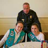 <p>Fairfield Police Department Capt. Joshua S. Zabin enjoys lunch with Scouts Zoe Feay (L) and Emma Fekete.</p>