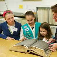 <p>Town Clerk Betsy Browne gives Scouts Ann Bonner (L), Ashley Appleby and Emma Lopes a tour of the vault, where vital records are kept. </p>