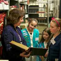 <p>Town Clerk Betsy Browne shows the Girl Scouts the records room.</p>