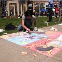 <p>Johan Garcia, 19, from Bridgeport, working on a creation at the Sidewalk Arts Festival.</p>