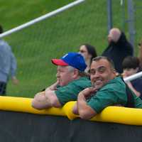 <p>Spectators watch from the outfield fence.</p>