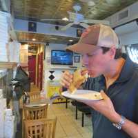 <p>Justin Vanoli of White Plains enjoys a regular slice at Broadway pizza.</p>