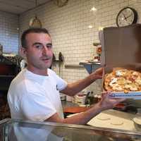 <p>Manager John Marleku with a burrata pie.</p>