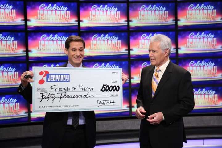 CNN Anchor John Berman accepts a ceremonial check from Alex Trebek, host of Celebrity Jeopardy! 