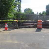 <p>A worker hired by the Village of Mamaroneck puts finishing touches on concrete Friday after a water line  was replaced over the North Barry Street Bridge.</p>