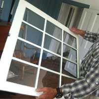 <p>Steve Gravereaux holds up half of a restored window in the Hanford-Silliman House.</p>