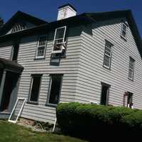 <p>Preservationist Donald Eldon takes out a second story storm window, in order to work on a window at the Hanford-Silliman House.</p>