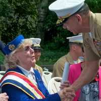 <p>Grand Marshal Beatrice Gorman (L) greets a member of the armed forces.</p>