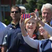 <p>Hillary Clinton pauses for what looks like a selfie attempt.</p>