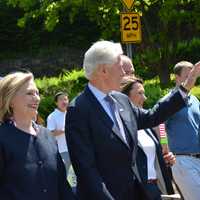 <p>Bill Clinton waves while marching in downtown Chappaqua, with New Castle Supervisor Rob Greenstein walking with him.</p>