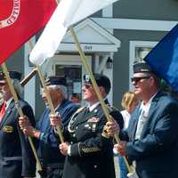 <p>Members of the armed forces carry flags at Monday&#x27;s parade.</p>