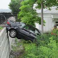 <p>The late-model car hangs precariously off the library wall.</p>