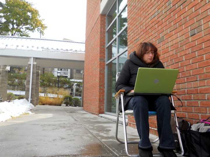 A resident sits outside the Ossining Public Library in October 2011 after a freak snowstorm knocked out power to much of Westchester County. 