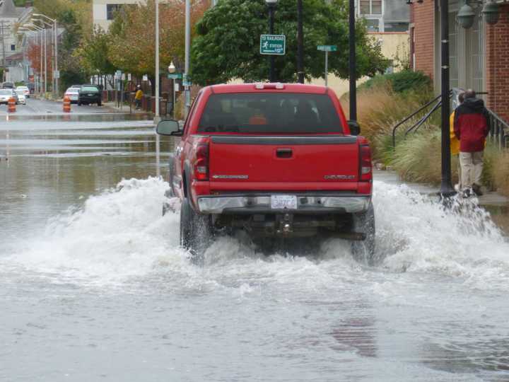 A truck bypassed barriers blocking off a section of Water Street in Norwalk as tidal surges flooded the street during a previous storm.