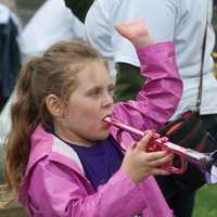 <p>A little girl blows her horn while watching the Great Street Parade.</p>