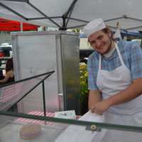 <p>Alessandro Dipierro from Brewster Pastry bags up some goodies at the Danbury Farmers Market. </p>