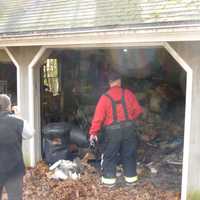 <p>Maxine McAvity, left, and Rowayton Fire Chief Ed Carlson survey the damage from a garage fire Friday at McAvity&#x27;s home on Little Brook Road in Rowayton.</p>