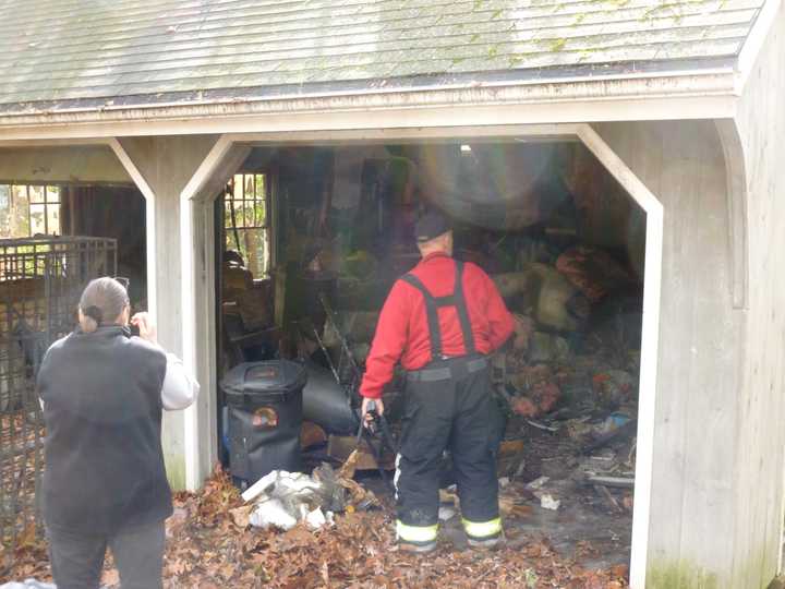 Maxine McAvity, left, and Rowayton Fire Chief Ed Carlson survey the damage from a garage fire Friday at McAvity&#x27;s home on Little Brook Road in Rowayton.