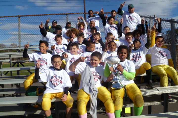 The fourth-grade Norwalk Packers football team celebrates Sunday after winning the Colonial League championship.