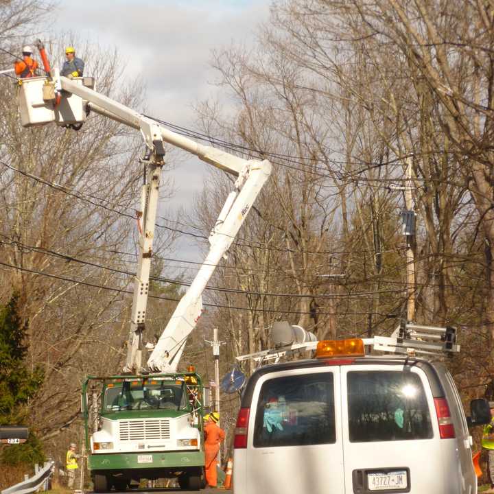 Power crews work on lines Monday morning along Route 124 in South Salem.