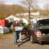 <p>Town employee Chris Curran helps a resident pick up some bottled water Monday at the Town House.</p>