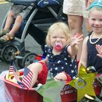 <p>Two young girls wave as they pass by in Saturday&#x27;s Push-n-Pull Parade.</p>