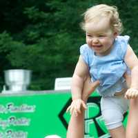 <p>A young girl is tossed in the air by a parent Saturday at Tilley Pond Park.</p>