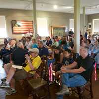 <p>A small crowd listens to portions of the Declaration of Independence.</p>