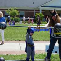 <p>Batwoman (aka Rebecca Newman) preps Batman for his turn weightlifting.</p>