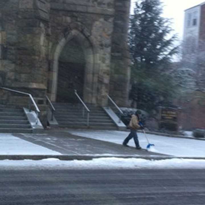 A worker clears the sidewalk at St. Peter&#x27;s Church on Main Street in Danbury late Wednesday afternoon.