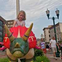 <p>A girl rides one of the dinosaurs around Columbus Park.</p>