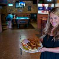 <p>South Side&#x27;s Jackie Gallaher shows off one of the restaurant&#x27;s most popular burgers, the South Side BBQ Pulled Pork Burger.</p>