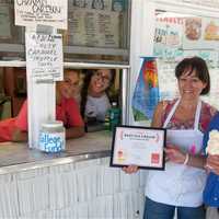 <p>Daily Voice Managing Editor Joe Lombardi presents DVlicious certificate to Scoops N&#x27; More staff.</p>