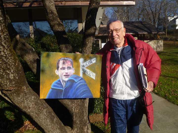 Keith Brooks, who is launching Occupy Weston, poses with a picture he painted that relates to the financial crisis.