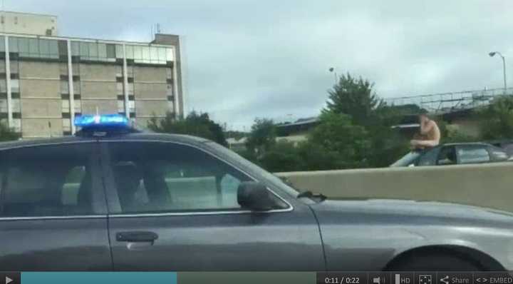 Police stop along I-95 to apprehend a naked man riding atop a car in West Haven. 