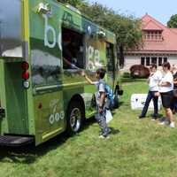 <p>Customers of all ages order food from the Bodega Taco Truck on the Great Lawn of Pequot Library during the 2014 Summer Book Sale.</p>