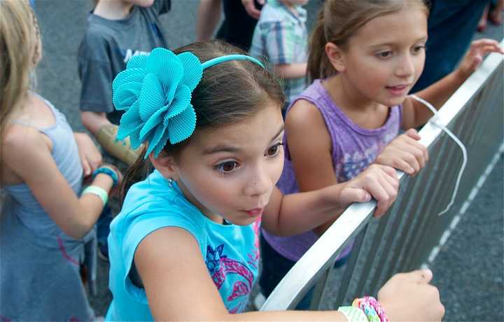 Two girls watch the action at the carnival.