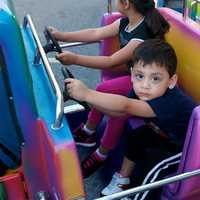 <p>A boy takes a ride in the kiddie ride area at the MVFD carnival.</p>