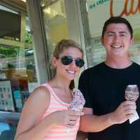 <p>Haley Gallagher and Michael McCormick enjoy a cool ice cream in Ridgefield Saturday.</p>